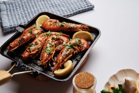 Grilled large queen shrimps with lemon and spices on grill pan